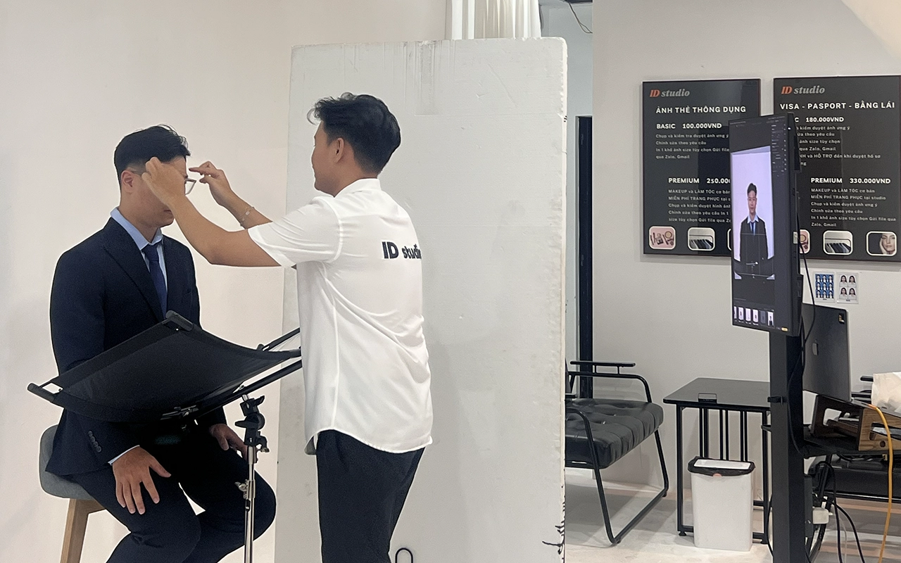 Nhân viên studio chỉnh tóc và hỗ trợ ngoại hình cho khách trước khi chụp ảnh CV tại thủ dầu một bình dương