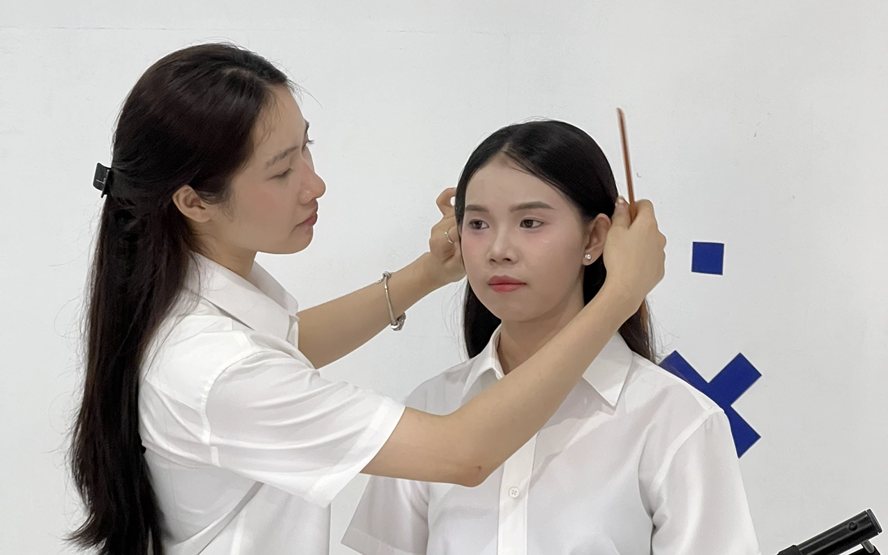 nhân viên chỉnh tóc và tác phong trước khi chụp ảnh passport visa tại ID Studio Bình Dương